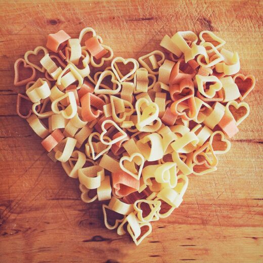 Heart-shaped pasta arranged on a wooden board for Valentines day in Italy