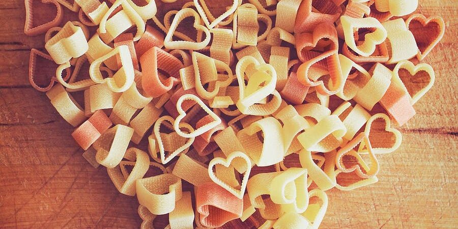 Heart-shaped pasta arranged on a wooden board for Valentines day in Italy