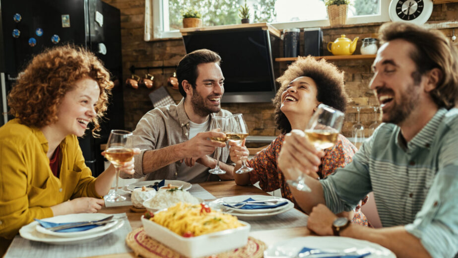 happy-couple-toasting-with-wine-having-fun-with-their-friends-dining-table