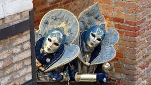 People wearing traditional Venetian Carnival masks during Carnevale celebrations in Venice.